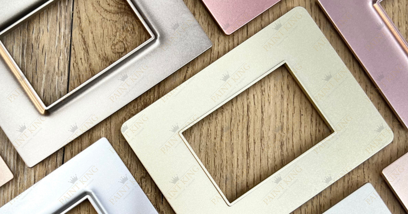 A collection of spray-painted switch plates in various metallic finishes, including gold, silver, copper, and bronze.