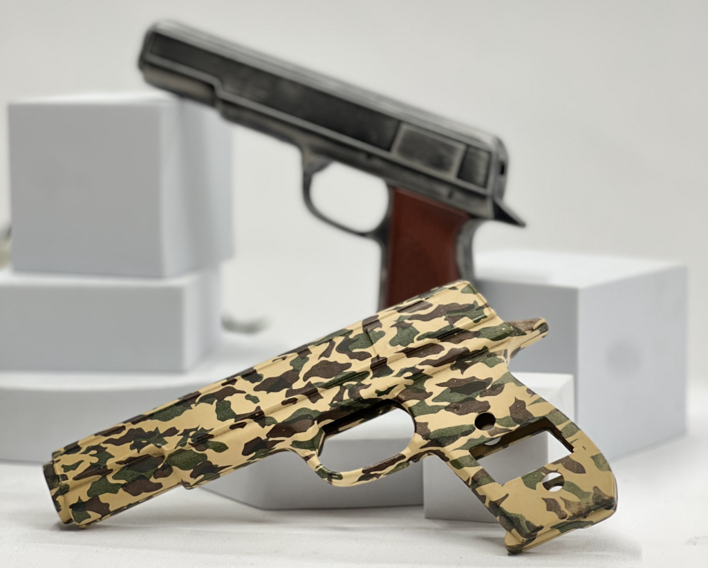 Two handguns, one with a traditional black finish and the other with a camouflage hydro-dipped pattern.