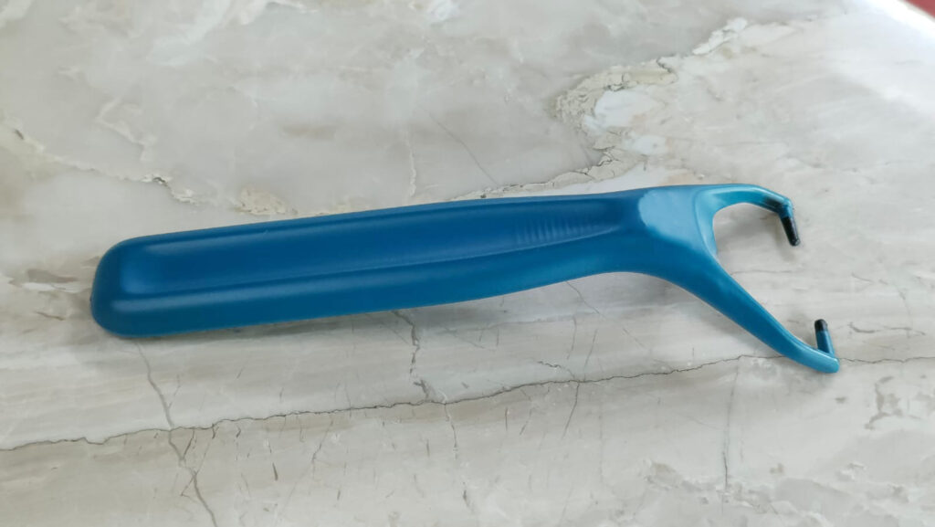 A close-up of a blue, ergonomic shaving blade handle with a rubberized finish.