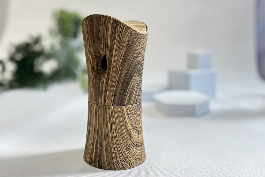 A brown, wooden textured fragrance diffuser with a curved top and a small hole for mist.