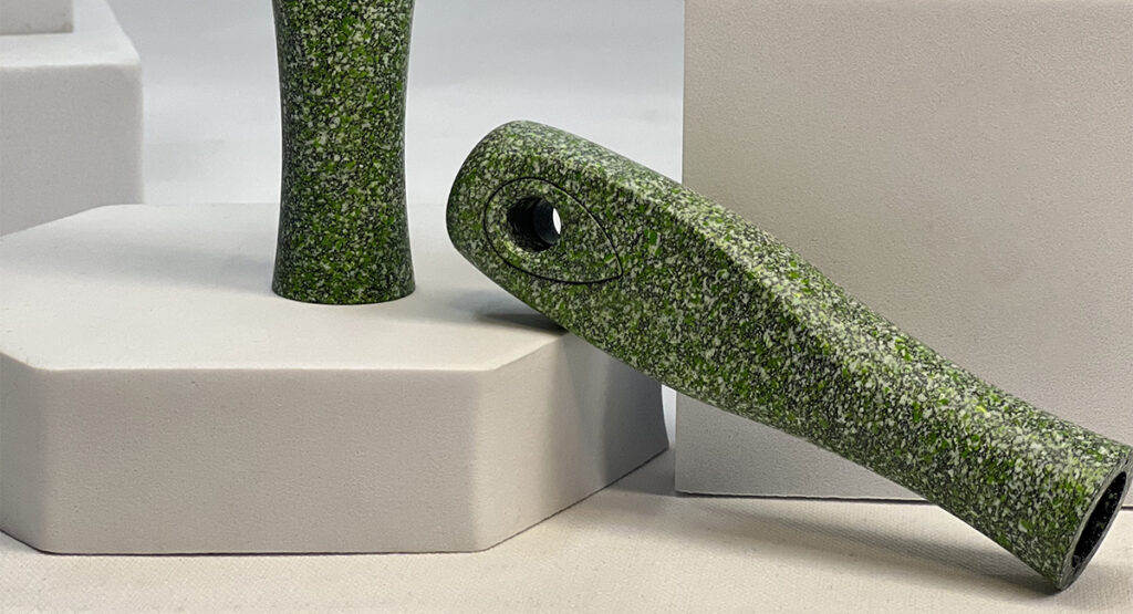 Two green spray-painted handles with a speckled texture, resting on white platforms.