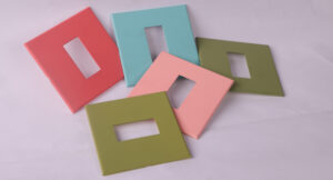 Five square switch plates in various pastel colors, including pink, blue, green, red, and white.